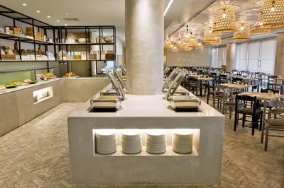 a restaurant with tables and plates on a counter at Blue Sky City Beach Hotel in Rhodes Town