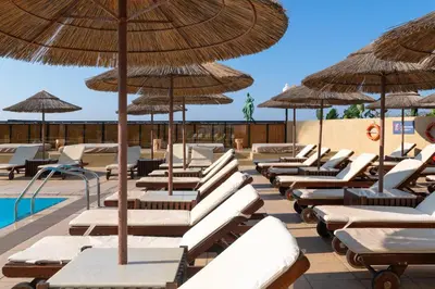 a row of lounge chairs and umbrellas at a resort at Blue Sky City Beach Hotel in Rhodes Town