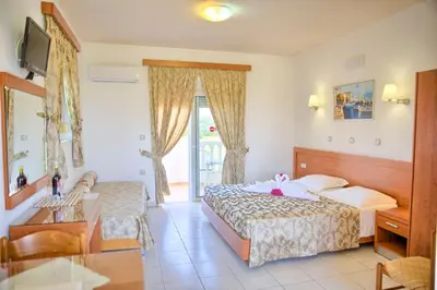 a hotel room with two beds and a table at Paul's Garden Studios in Haraki