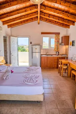 a kitchen with two beds in a room at Paul's Garden Studios in Haraki