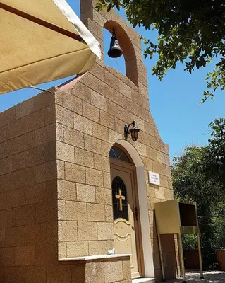a small church with a cross on the door at Paul's Garden Studios in Haraki