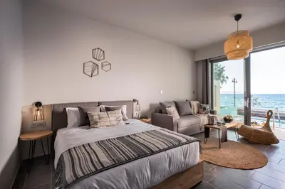 a bedroom with a large bed and a couch at Villa Di Mare Seaside Suites in Ixia