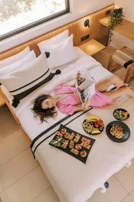 a girl laying on a bed with food on it at Villa Di Mare Seaside Suites in Ixia