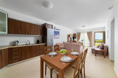 a kitchen and living room with a table and chairs at Kolymbia Village in Kolimbia