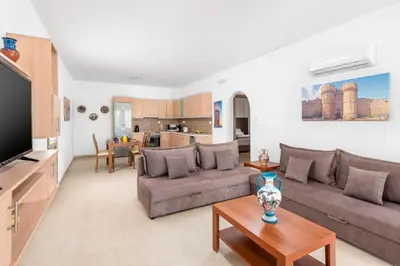 a living room with a couch and a table at Kolymbia Village in Kolimbia
