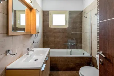 a bathroom with a sink and a tub and a toilet at Kolymbia Village in Kolimbia