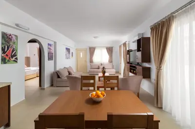 a living room with a dining table and a living room at Kolymbia Village in Kolimbia