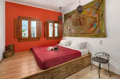 a bed in a room with a red wall at Villa Anastasia in Líndos