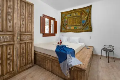a bedroom with a bed with a blue blanket on it at Villa Anastasia in Líndos