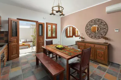 a dining room with a wooden table and chairs at Villa Anastasia in Líndos