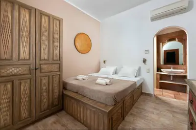 a bedroom with a bed and a sink and a mirror at Villa Eleni with Hot Tub and Acropolis View in Líndos