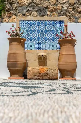 three vases with flowers in them on a wall at Villa Eleni with Hot Tub and Acropolis View in Líndos