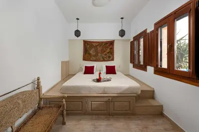 a bedroom with a bed with red pillows at Villa Eleni with Hot Tub and Acropolis View in Líndos