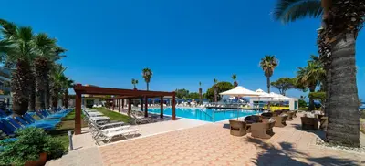 a resort with a pool and chairs and palm trees at All Senses Ocean Blue Sea Side Resort - All Inclusive in Kremasti