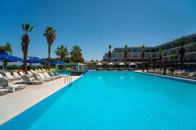 a large swimming pool with chairs and umbrellas at All Senses Ocean Blue Sea Side Resort - All Inclusive in Kremasti