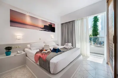a bedroom with a large bed and a large window at Esperia City Hotel in Rhodes Town