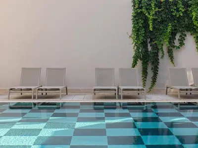 a row of white chairs sitting next to a pool at Esperia City Hotel in Rhodes Town