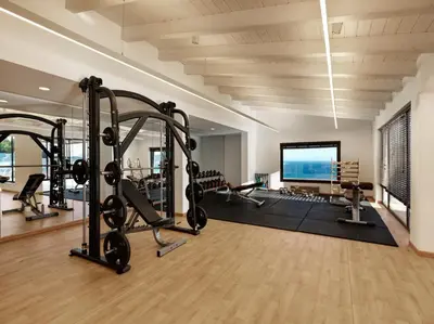 a gym with treadmills and cardio equipment in a building at Esperos Village Blue & Spa - Adults Only in Faliraki