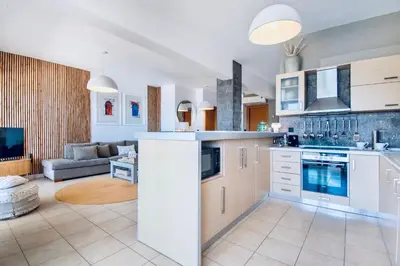 a kitchen with white cabinets and a living room at Villa Lindos Kalliopi on Rhodes AMA 0 0 0 0 3 6 6 0 4 0 3 in Líndos