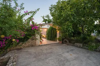 a driveway leading to a house with flowers at Lila's house in Eleoúsa