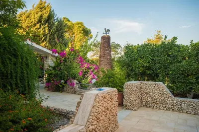 a garden with a bench and flowers and trees at Lila's house in Eleoúsa