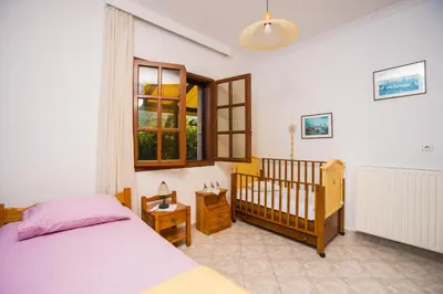 a bedroom with a bed and a baby crib at Lila's house in Eleoúsa