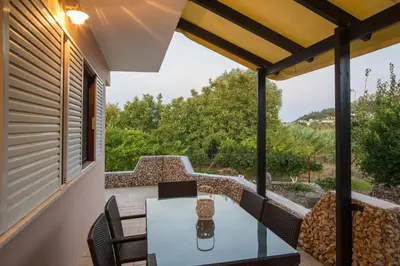 a patio with a table and chairs on a balcony at Lila's house in Eleoúsa