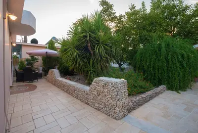 a garden with a bench and a table and trees at Lila's house in Eleoúsa