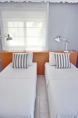 two beds in a room with a window at Alkyoni City Apartment in Rhodes Town