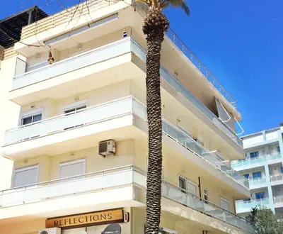 a palm tree in front of a building at Alkyoni City Apartment in Rhodes Town