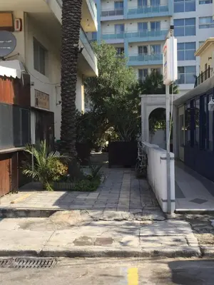 a sidewalk in front of a building with a palm tree at Alkyoni City Apartment in Rhodes Town