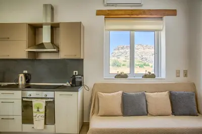 a kitchen with a couch in front of a window at G&K Stone Suites in Haraki