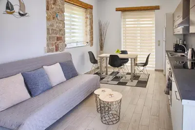 a living room with a blue couch and a kitchen at G&K Stone Suites in Haraki