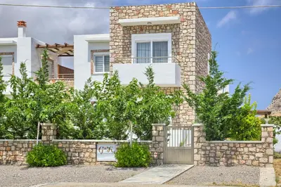 a brick house with a gate and a stone wall at G&K Stone Suites in Haraki