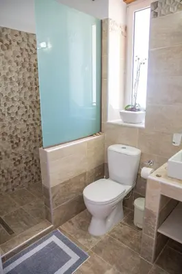 a bathroom with a toilet and a shower and a sink at G&K Stone Suites in Haraki