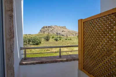 a window with a view of a mountain at Haraki Stone Apartments in Haraki