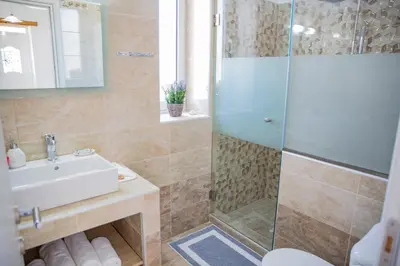 a bathroom with a shower and a sink at Haraki Stone Apartments in Haraki