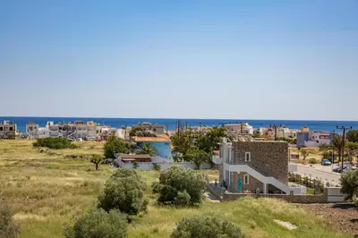 a view of a town with the ocean in the background at Haraki Stone Apartments in Haraki