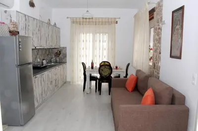 a kitchen and a living room with a couch and a table at Haraki Stone Apartments in Haraki