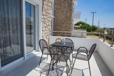 a black table and chairs on a balcony at Haraki Stone Apartments in Haraki