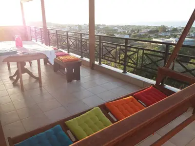 a balcony with a table and colorful pillows on it at Stan&Family in Kalavárda