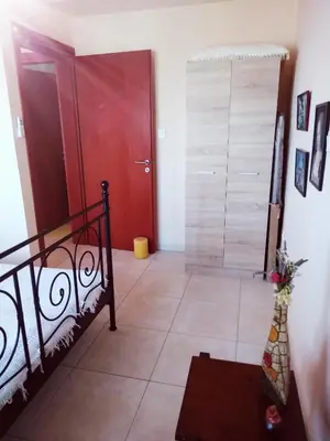 a room with a staircase and a red door at Stan&Family in Kalavárda