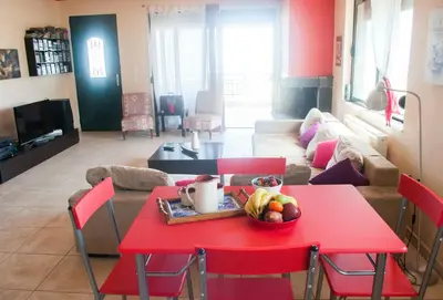 a red table and chairs in a living room at Stan&Family in Kalavárda