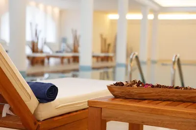 a bowl of flowers sitting on a table next to a bed at All Senses Nautica Blue Exclusive Resort & Spa - All Inclusive in Phanaes