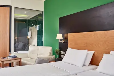 a bedroom with a bed and a bath room at All Senses Nautica Blue Exclusive Resort & Spa - All Inclusive in Phanaes