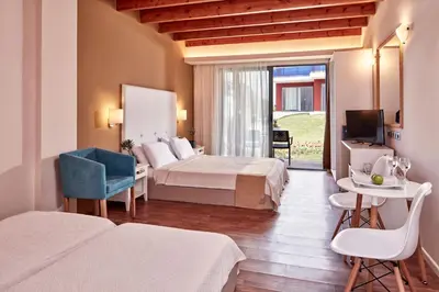 a hotel room with two beds and a television at All Senses Nautica Blue Exclusive Resort & Spa - All Inclusive in Phanaes