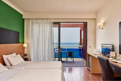 a hotel room with a bed and a desk with a view at All Senses Nautica Blue Exclusive Resort & Spa - All Inclusive in Phanaes