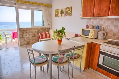 a kitchen with a table and chairs and a table at Chara's Sea View House in Haraki