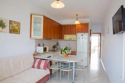 a kitchen and a living room with a couch and a table at Chara's Sea View House in Haraki