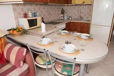 a kitchen with a table with plates and glasses on it at Chara's Sea View House in Haraki